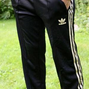 Adidas womans black shiny pants hand pocket pose front