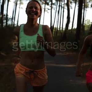 two-female-athletes-running-in-the-forest-by-the-beach-in-the-south-video-id497429978.mp4