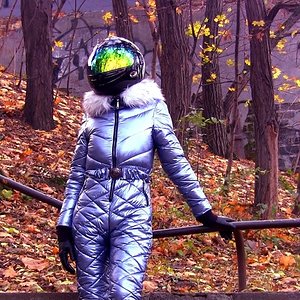 A shiny blue ski suit + modern motorcycle helmet. Walking in spacesuit through the ruins of the past