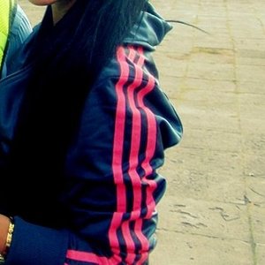 Adidas womans black jacket with red stripes close sleeve shot