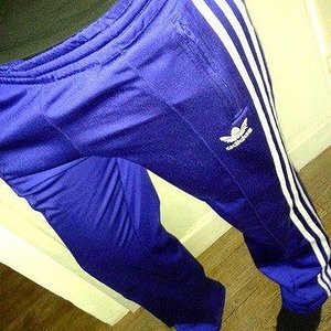 Adidas womans blue pants with white stripe tilted close angle shot small logo
