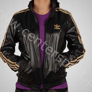 Adidas womans shiny black jacket gold trim side logo front pocket pose