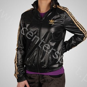 Adidas womans shiny black jacket gold trim side logo front hip pose