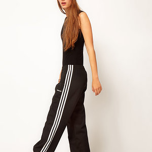 Adidas womens black pants with white stripes long legs pose