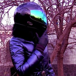 Alpine skiing blue shiny overalls with hood and belt, a black motorcycle helmet. Inspection of ruins