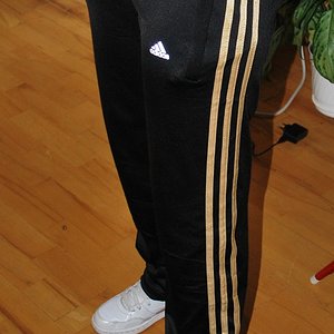Adidas womens black pants gold stripe angle stand pose