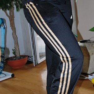 Adidas womens black pants gold stripe side knee pose