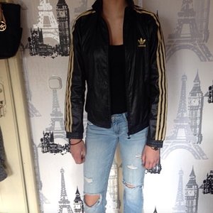 Skinny Girl wearing Adidas black and gold windbreaker Jacket