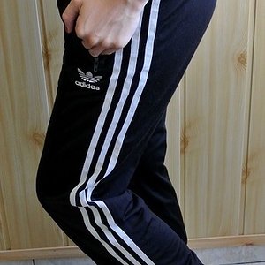 Girl in black Adidas Firebird pants