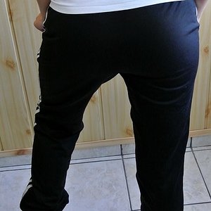 Girl in black Adidas Firebird pants