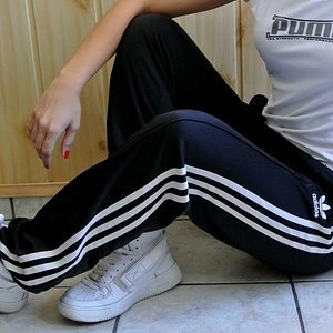 Girl in black Adidas Firebird pants