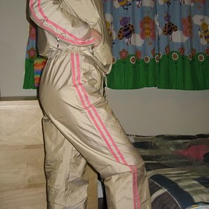 Woman wearing tan and pink shellsuit, another side shot