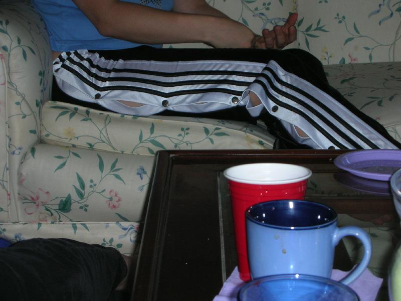 Adidas womans black pants large white stripes sitting side shot