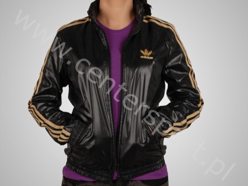 Adidas womans shiny black jacket gold trim side logo front pocket pose