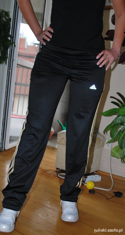 Adidas womens black pants gold stripe front leg pose