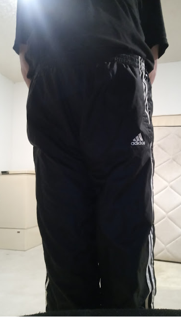 Me wearing my Small Black Adidas Nylon Pants with my hands behind my back 1