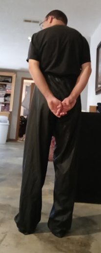 Me with my hands behind my back in my Black Shirt and Black Polyester Pants (back 2)