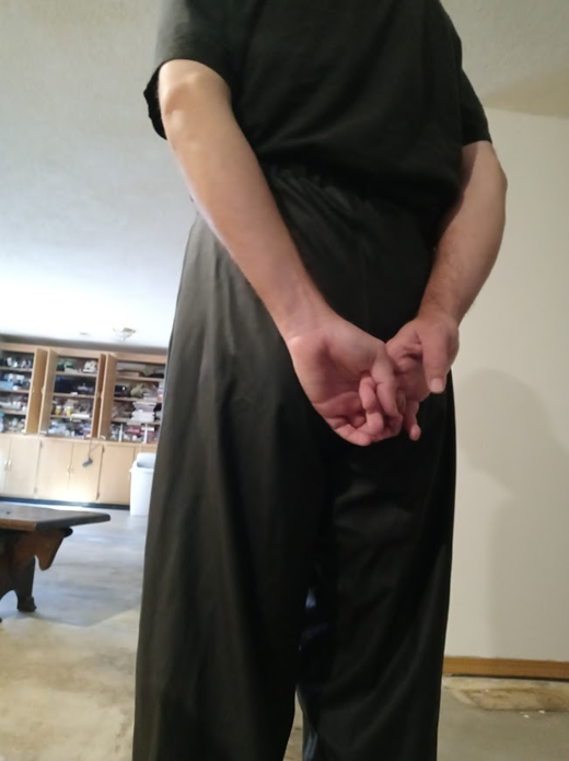 Me with my hands behind my back in my Black Shirt and Black Polyester Pants (back)