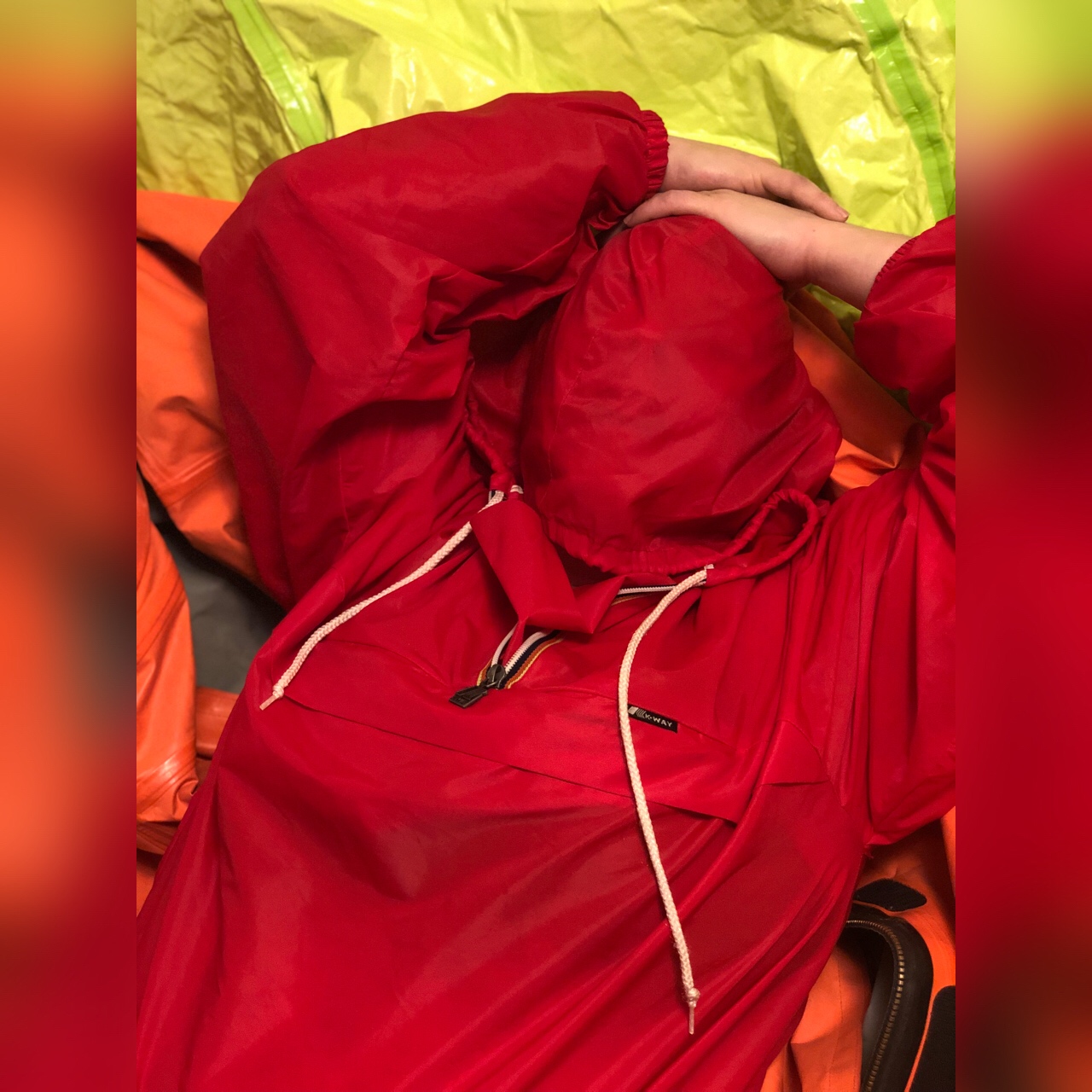 Red k-way pullover and a pile of hazmat suits