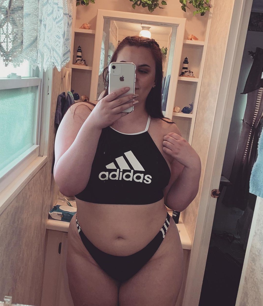 Sexy girl teasing in her adidas swimsuit