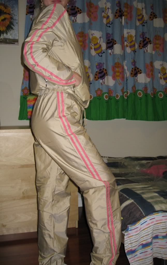 Woman wearing tan and pink shellsuit, another side shot