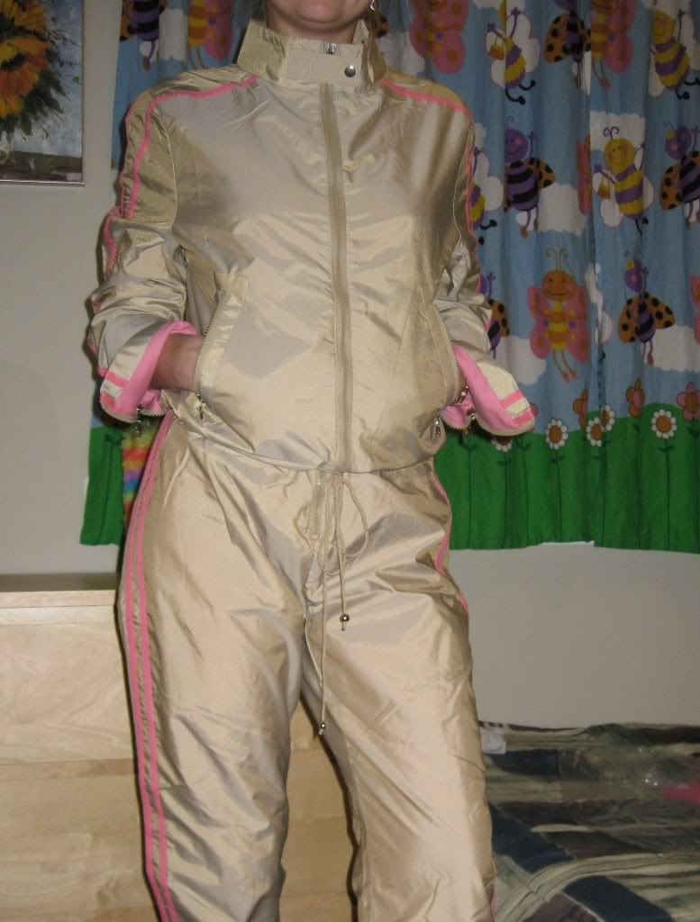 Woman wearing tan and pink shellsuit, front shot